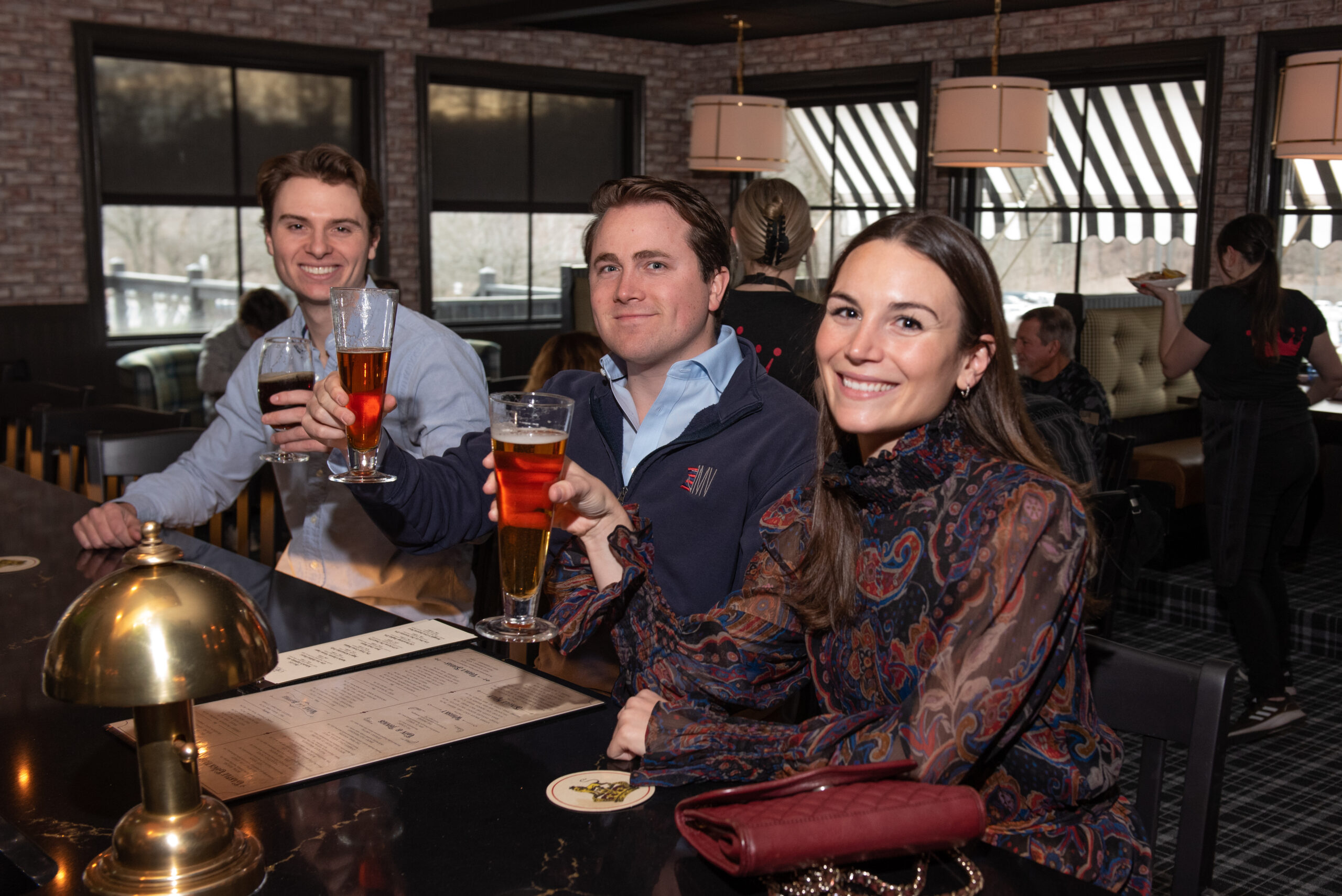 Three people raising a glass at the best bar in Glen Mills, PA